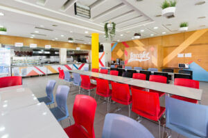 Intérieur du restaurant d'entreprise Lacafet Ompic, avec un espace de restauration spacieux, des couleurs vives et une ambiance conviviale.