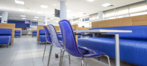 Chaises et banquettes bleues modernes dans le restaurant universitaire Lacafet UM6SS, design fonctionnel et convivial pour l'espace de restauration des étudiants.