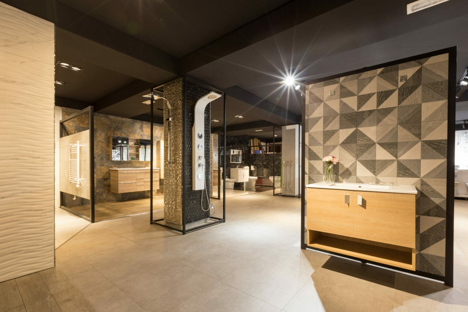 Exposition d'un ensemble de salle de bain dans le showroom AZ Living, mettant en avant des toilettes modernes et des meubles de rangement en bois, entourés de carrelages décoratifs colorés et texturés. Conçu par architecte d'intérieur Anas Taleb