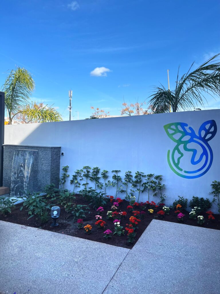 Aménagement paysager avec jardin fleuri et logo écologique sur le mur au Sustainable Construction Lab de LafargeHolcim