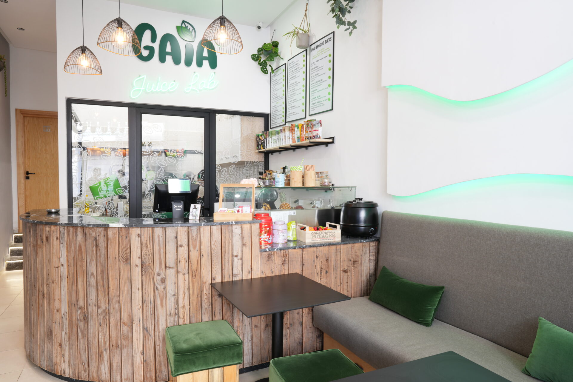 Intérieur du GAIA Juice avec un comptoir en bois, des sièges confortables et une ambiance naturelle et lumineuse.