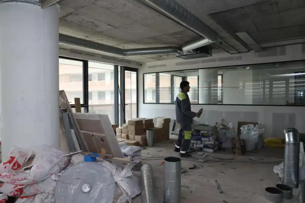 Installation des conduits de ventilation et climatisation (HVAC) au plafond d'un plateau de bureaux en travaux.